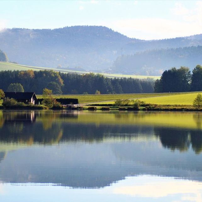 Log cabin porch overlooking still water